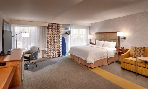 盐湖城盐湖城市区汉普顿酒店的酒店客房配有一张床、一张书桌和一台电视。