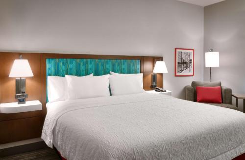 德雷珀Hampton Inn Draper Salt Lake City, Ut的一间卧室配有一张大床和一张红色椅子