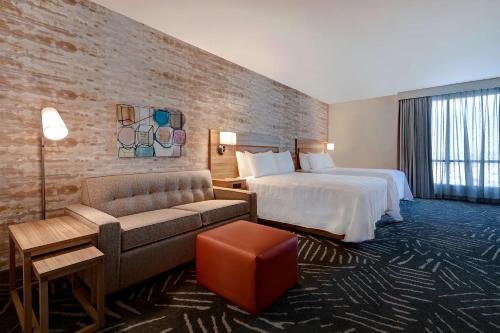 安纳海姆Home2 Suites By Hilton Anaheim Resort的酒店客房,配有床和沙发