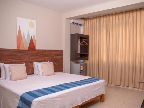 普卡尔帕Leveint Executive Hotel的一间卧室配有一张大床和电视