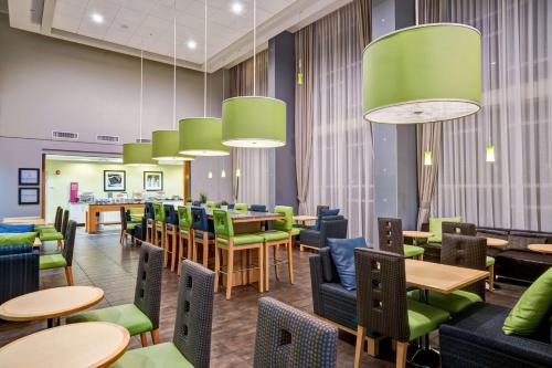 萨拉索塔汉普顿酒店&套房萨拉索塔/布雷登顿 - 机场的一间设有桌子和绿色椅子的等候室