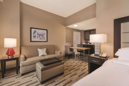 塔斯卡卢萨Embassy Suites by Hilton Tuscaloosa Alabama Downtown的酒店客房配有床、沙发和桌子。