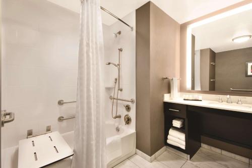 塔斯卡卢萨Embassy Suites by Hilton Tuscaloosa Alabama Downtown的带浴缸、水槽和淋浴的浴室