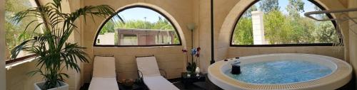 奥斯图尼特鲁利奥拉西亚度假屋的一间带大浴缸的浴室,设有两个窗户