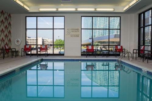 塔尔萨Hampton Inn & Suites Tulsa Downtown, Ok的一个带桌椅和窗户的游泳池