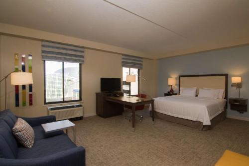塔尔萨Hampton Inn & Suites Tulsa Downtown, Ok的一间卧室配有一张床、一张桌子和一张沙发