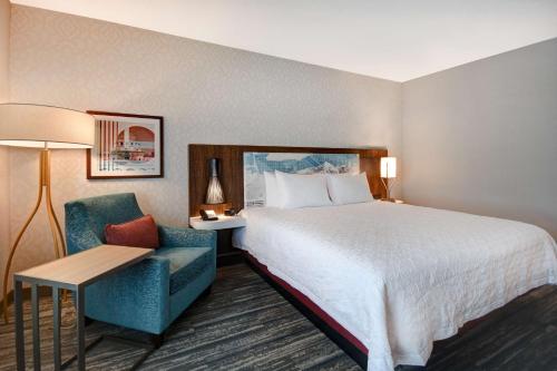 土桑Hampton Inn Tucson Downtown, Az的配有一张床和一把椅子的酒店客房
