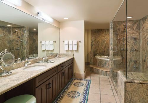 土桑图森希尔顿度假酒店的一间带两个盥洗盆和淋浴的浴室