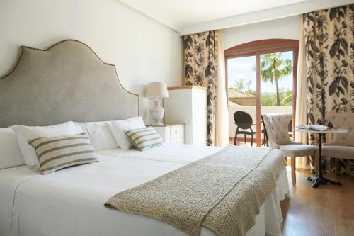 比纽埃拉B bou Hotel La Viñuela & Spa的卧室设有一张白色大床和一扇窗户。