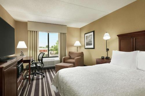 尚蒂伊华盛顿杜勒斯国际机场南希尔顿恒庭酒店的酒店客房配有一张床、一张桌子和一把椅子。