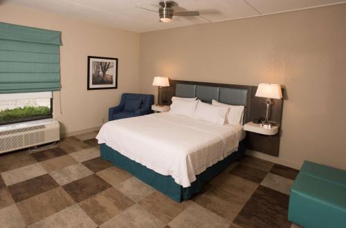 伍斯特伍斯特汉普顿酒店的一间卧室配有一张床和一张蓝色椅子