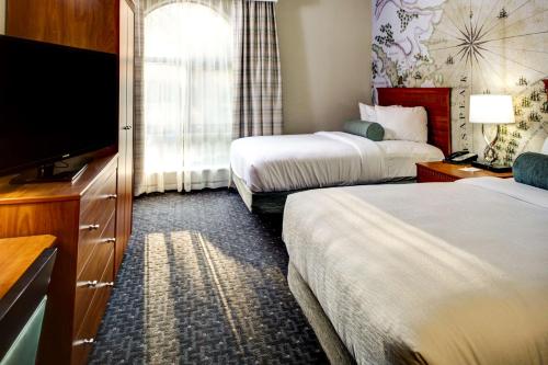 威廉斯堡威廉斯堡大使馆套房酒店的酒店客房设有两张床和一台平面电视。