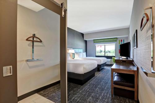 圣凯瑟琳市Hampton Inn St. Catharines Niagara的酒店客房,配有床和电视