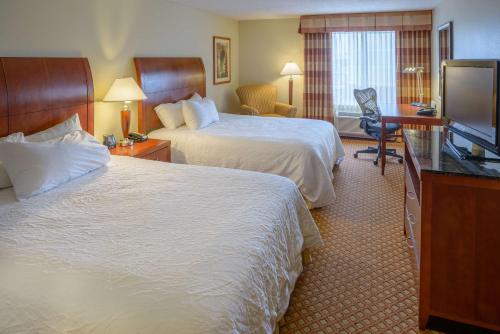 乔普林乔普林希尔顿花园旅馆的酒店客房设有两张床和一台平面电视。