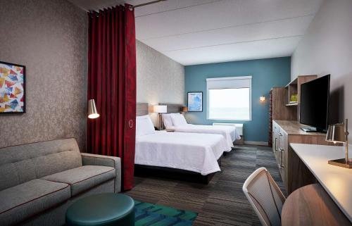 布兰特福德Home2 Suites By Hilton Brantford的酒店客房,设有两张床和一张沙发