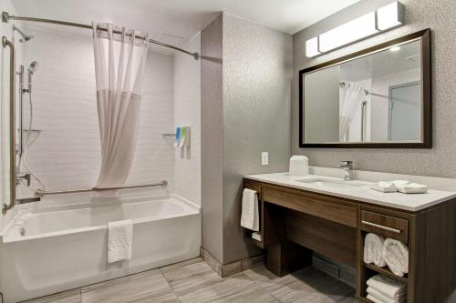 埃德蒙顿Home2 Suites By Hilton Edmonton South的带浴缸、水槽和镜子的浴室