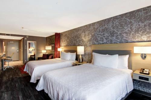 埃德蒙顿Home2 Suites By Hilton Edmonton South的酒店客房,配有两张带白色床单的床