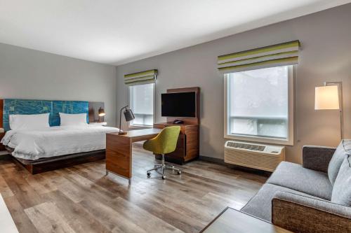 埃德蒙顿汉普顿酒店及套房埃德蒙顿/西的酒店客房配有一张床、一张书桌和一张沙发。