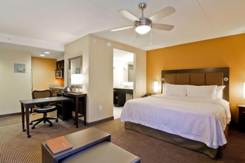 滑铁卢滑铁卢/圣雅各布希尔顿惠庭套房酒店的酒店客房带一张床铺、一张书桌和一间卧室