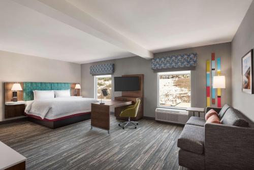 基洛纳Hampton Inn & Suites Kelowna, British Columbia, Canada的酒店客房配有床、沙发和电视。