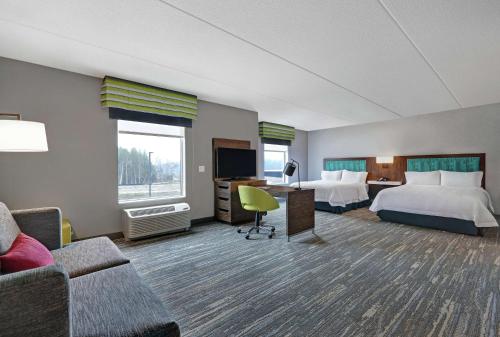彼得伯勒Hampton Inn Peterborough的酒店客房,设有两张床和一张沙发