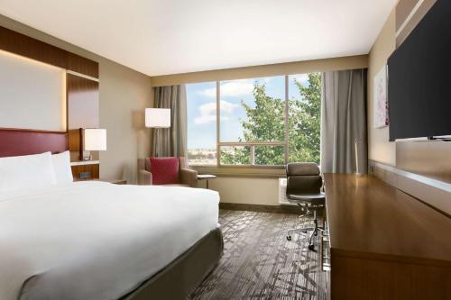 米西索加希尔顿逸林酒店多伦多机场西店的酒店客房设有一张床和一个大窗户