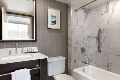 潘特克莱尔蒙特利尔机场希尔顿大使馆套房酒店 的浴室配有卫生间、盥洗盆和淋浴。