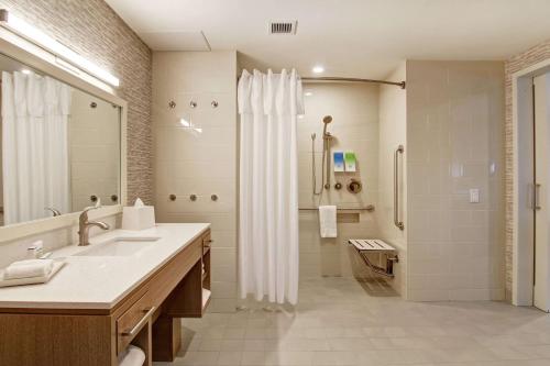 多瓦尔Home2 Suites By Hilton Montreal Dorval的浴室配有水槽和带浴帘的淋浴