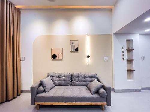 岘港Central, Minimalist and Cozy - Gau's House的客厅的墙上设有沙发