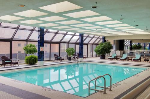 伦敦伦敦希尔顿逸林酒店的一座带天花板的建筑中的游泳池