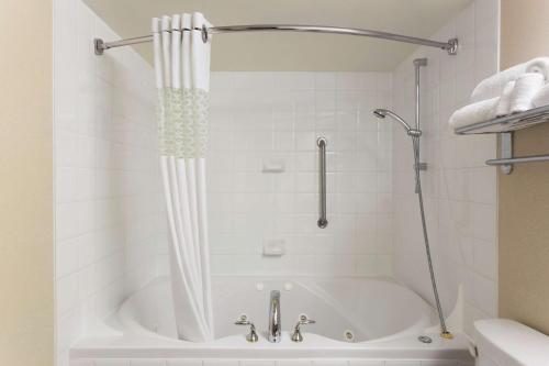 温哥华温哥华市中心汉普顿酒店的浴室内设有带浴帘的白色浴缸