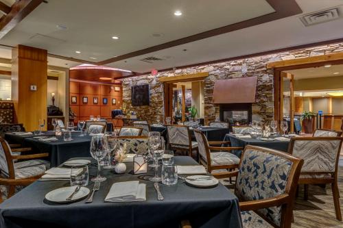 惠斯勒希尔顿惠斯勒度假村和温泉中心的一间设有蓝色桌椅和石墙的餐厅