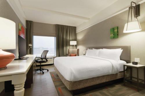 卡尔加里卡尔加里市中心希尔顿花园酒店的酒店客房设有一张白色大床和一张书桌
