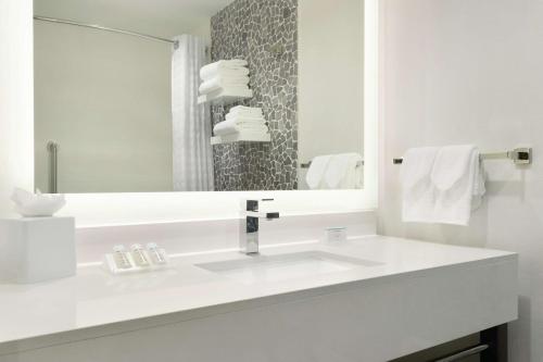 卡尔加里卡尔加里市中心希尔顿花园酒店的白色的浴室设有水槽和镜子