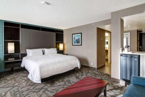 卡尔加里希尔顿卡尔加里机场汉普顿套房酒店的酒店客房设有床和客厅。