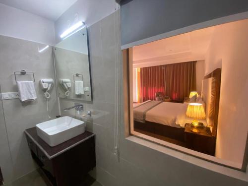 列城Lha-Zes的一间带水槽和镜子的浴室以及一张床
