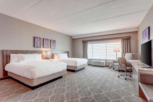 布兰普顿Hilton Garden Inn Toronto/Brampton West, Ontario, Canada的酒店客房配有两张床和一张书桌
