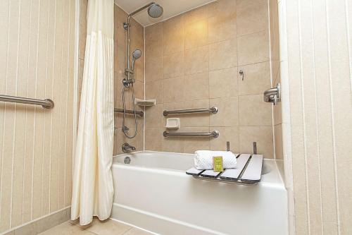 拉斐特拉斐特希尔顿逸林酒店的浴室配有白色浴缸和淋浴。