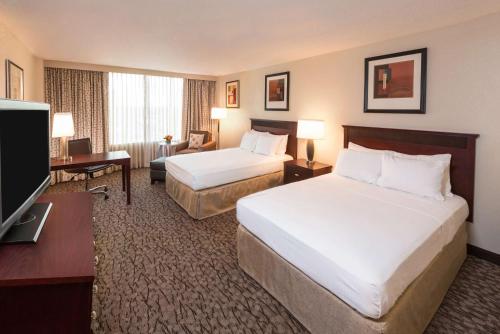 拉斐特拉斐特希尔顿逸林酒店的酒店客房设有两张床和一台平面电视。