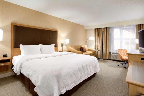 独立市克利夫兰汉普顿独立套房酒店的酒店客房带一张大床和一把椅子