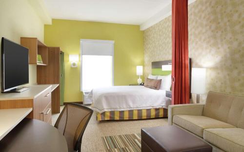 夏洛特夏洛特机场希尔顿欣庭套房酒店的酒店客房设有床和客厅。