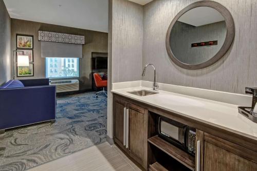 弗雷斯诺Hampton Inn Fresno Airport的酒店客房设有水槽和镜子