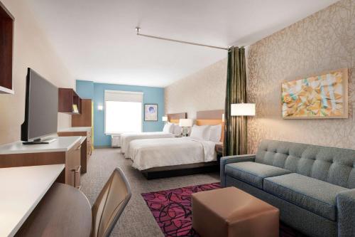 哈里斯堡Home2 Suites By Hilton Harrisburg的酒店客房,配有床和沙发