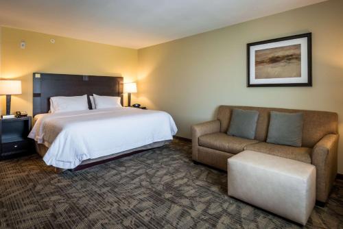 Whitestown西北印第安纳波利斯/宰恩斯维尔汉普顿酒店的配有一张床和一把椅子的酒店客房