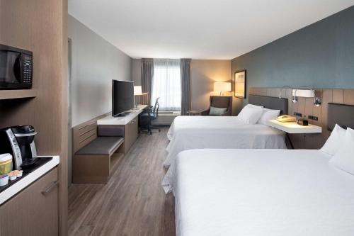 恩菲尔德哈利法克斯机场希尔顿花园酒店的酒店客房设有两张床和电视。