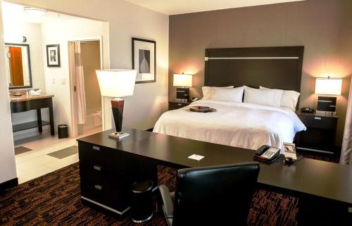 塔尔萨塔尔萨/塔尔萨山汉普顿酒店及套房 的一间卧室配有一张床和一张书桌及电话