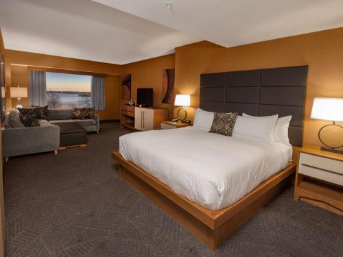 尼亚加拉瀑布纽约尼亚加拉瀑布希尔顿逸林酒店的酒店客房设有一张大床和一张沙发。