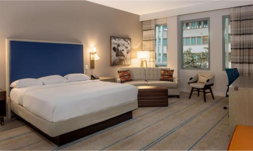 奥斯汀希尔顿奥斯汀机场酒店的卧室配有一张白色的大床和一张沙发。