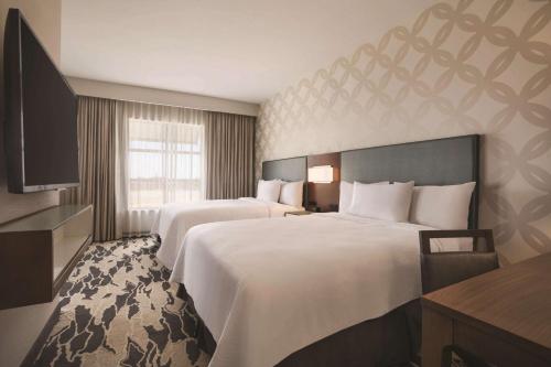 麦卡伦麦卡伦会展中心大使馆希尔顿套房酒店的酒店客房设有两张床和电视。