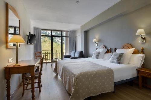 坎丹奇奥坎丹丘雪绒花酒店的酒店客房设有一张大床和一张书桌。
